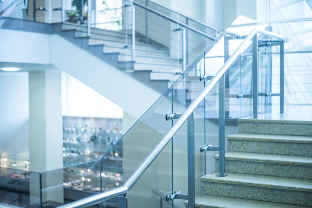 Balustrady całoszklane i samonośne – szkło bez słupków 1 Balustrada całoszklana przy schodach w nowoczesnym budynku – przykładowa aranżacja