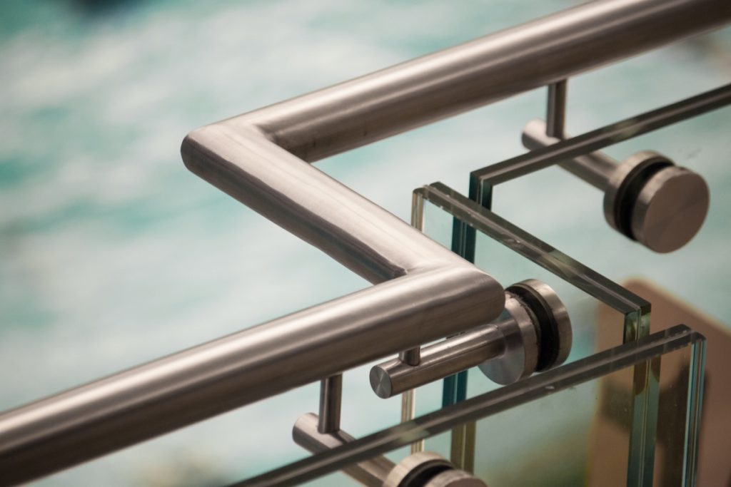 Balustrady całoszklane i samonośne – szkło bez słupków 2 Detal balustrady szklanej mocowanej punktowo na rotulach z pochwytem ze stali nierdzewnej
