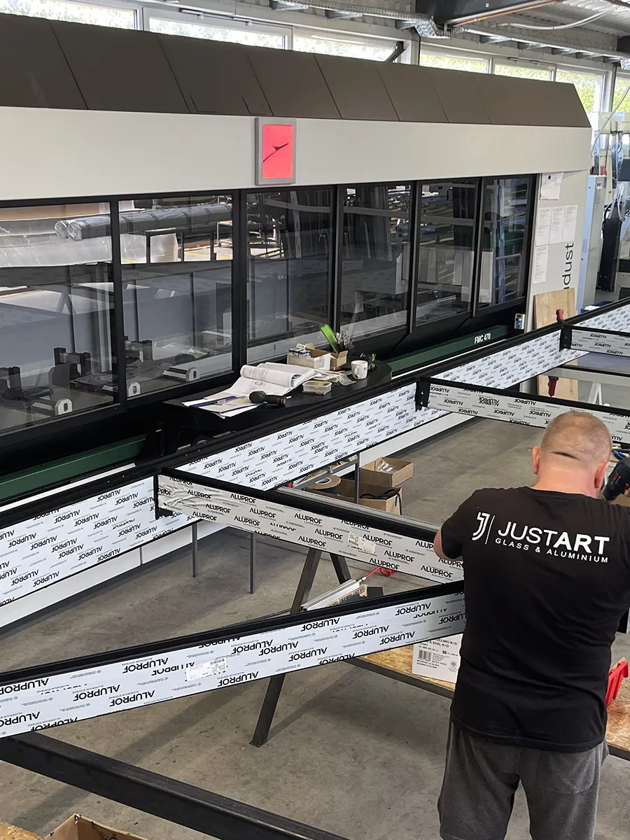 Drzwi loftowe aluminiowe na wymiar – Łódź i cała Polska 9 Pracownik Justart przy produkcji konstrukcji aluminiowych w Łodzi