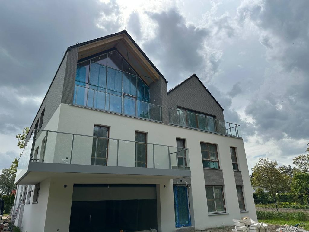 Balustrady całoszklane i samonośne – szkło bez słupków 7 Szklane balustrady w szczycie budynku i na balkonach – realizacja Justart